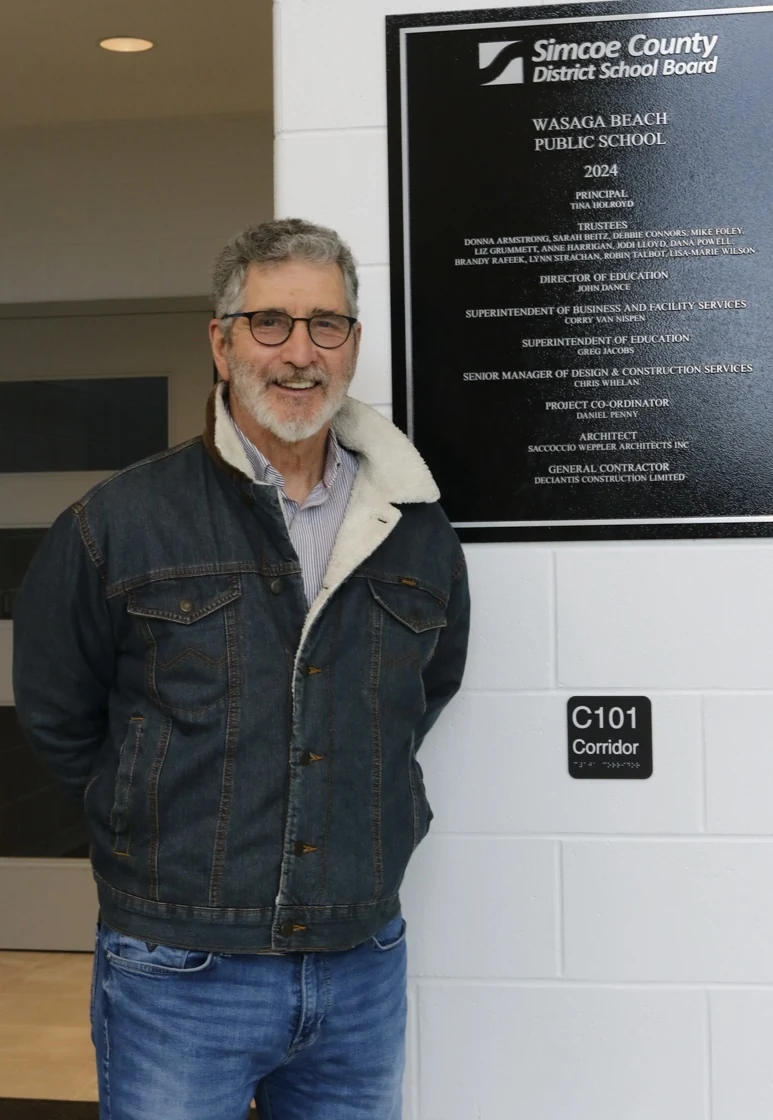 Mike Foley standing beside the Wasaga Beach Public School opening plaque